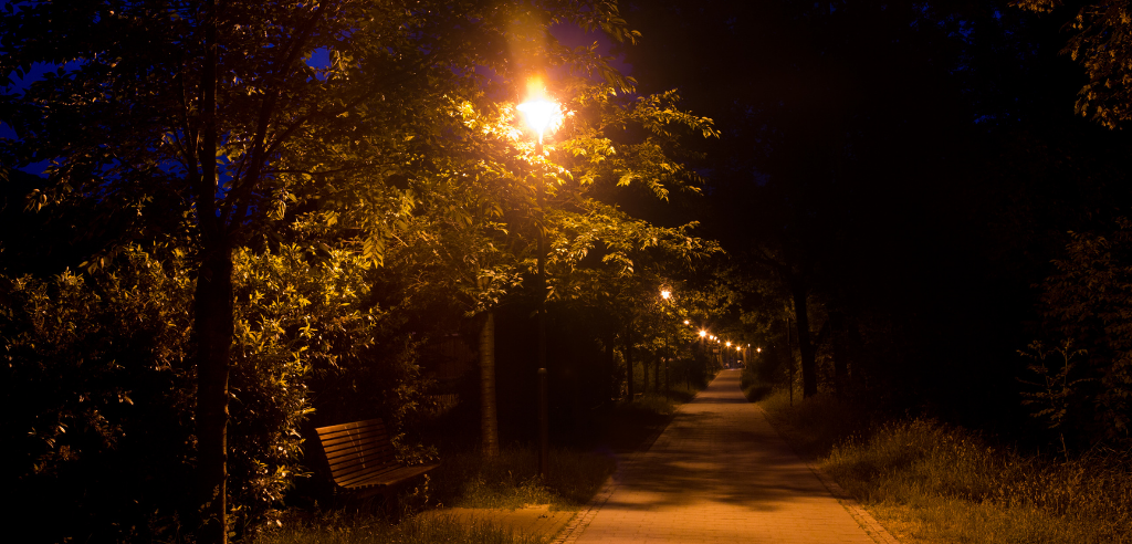 A dark path lit by a street light